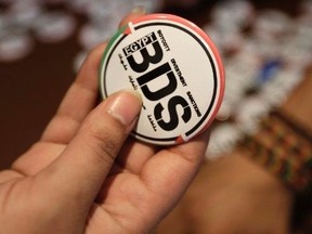 An Egyptian buys a pin with the Boycott, Divestment and Sanctions logo at the Egyptian Journalists Syndicate in Cairo on April 20, 2015.