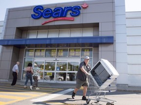 In this July 21, 2017 file photo, customers enter and leave the Sears store in St. Eustache, Quebec.