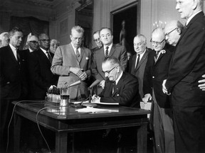 FILE - This July 2, 1964 file photo shows President Lyndon Baines Johnson signing the Civil Rights Act in the East Room of the White House in Washington. Standing, from left, are Sen. Everett Dirksen, R-Ill.; Rep. Clarence Brown, R-Ohio; Sen. Hubert Humphrey, D-Minn.; Rep. Charles Halleck, R-Ind.; Rep. William McCullough, R-Ohio; and Rep. Emanuel Celler, D-N.Y. The Civil Rights Act of 1964 is considered one of the most celebrated legislative achievements in U.S. history. Signed on July 2, 1964 by President Lyndon B. Johnson, this law made it illegal to discriminate on the basis of race, color, religion, sex, or national origin, and barred unequal application of voter registration requirements.