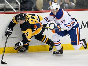 In this Nov. 8, 2016, file photo, Connor McDavid and Sidney Crosby battle for the puck. (AP Photo/Gene J. Puskar, File)