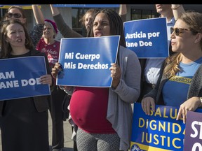 Activists with Planned Parenthood demonstrate in support of a pregnant 17-year-old being held in a Texas facility for unaccompanied immigrant children to obtain an abortion, outside of the Department of Health and Human Services in Washington, Friday, Oct. 20, 2017. (AP Photo/J. Scott Applewhite)