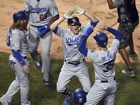 Dodgers' Enrique Hernandez (centre) celebrates his grand slam during the third inning against the Cubs in Game 5 of the NL Championship Series at Wrigley Field in Chicago on Thursday, Oct. 19, 2017. (John Starks/Daily Herald via AP)