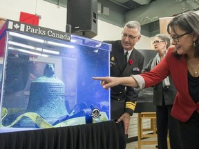Former Minister of the Environment Leona Aglukkaq and Royal Canadian Navy Rear Admiral John Newton look at the ship's bell from the discovered Franklin Expedition shipwreck HMS Erebus in Ottawa on Thursday, Nov. 6, 2014.