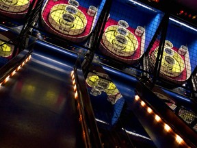A series of skee-ball games lined up in an arcade.