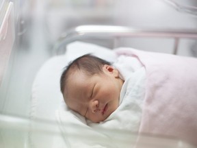 In this stock photo, a newborn baby girl is seen in hospital.