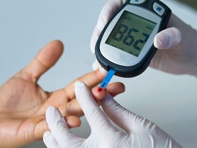 In this stock photo, a doctor measures a diabetic's blood glucose levels.