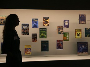 A member of British Library staff poses for a picture with Harry Potter books published in several languages at the "Harry Potter - A History of Magic" exhibition at the British Library, in London, Wednesday Oct. 18, 2017. The exhibition running from Oct. 20, marks the 20th anniversary of the publication of Harry Potter and the Philosopher's Stone, showing items from the British Library's collection, and items from author J.K Rowling and the book publisher's collection. (AP Photo/Tim Ireland)