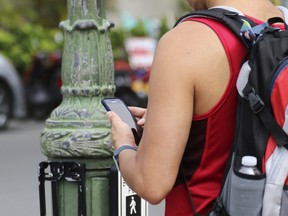 A man uses his cellphone before crossing a street in Honolulu on Wednesday, Oct. 25, 2017.