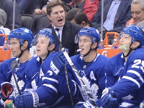Toronto Maple Leafs head coach Mike Babcock, top, talks to players Dominic Moore (20) Leo Komarov (47) Tyler Bozak (42) and James van Riemsdyk (25) on the bench during second period NHL hockey action against the New Jersey Devils in Toronto on Wednesday, October 11, 2017. THE CANADIAN PRESS/Nathan Denette