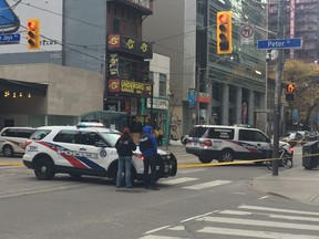 Toronto Police Emergency Task Force surround a King St. W. dispensary near Blue Jays Way Thursday afternoon after reports of a man with a gun.