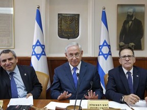 Israeli Prime Minister Benjamin Netanyahu, center, attend the weekly cabinet meeting at the prime minister's office in Jerusalem, Sunday, Oct. 15, 2017.