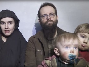 In this file image from video released by Taliban Media in December 2016, Caitlan Coleman talks in the video while her Canadian husband Joshua Boyle holds their two children. The couple and their three children were rescued Oct. 12, 2017, five years after the couple was abducted in Afghanistan on a backpacking trip. The children were born in captivity. (Taliban Media via AP)