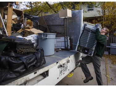 Liam Hamilton, of JUSTJUNK, helps to clear out various thing no longer needed from a home in Toronto, Ont. on Wednesday October 25, 2017.