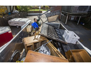 Liam Hamilton, of JUSTJUNK, helps to clear out various thing no longer needed from a home in Toronto, Ont. on Wednesday October 25, 2017.