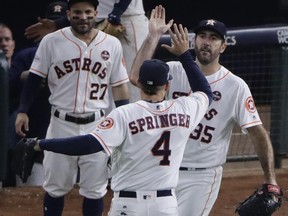 Astros' Justin Verlander (right) congratulates George Springer (4) after a catch at the wall of a ball hit by the Yankees' Todd Frazier during the seventh inning of Game 6 of the AL Championship Series in Houston on Friday, Oct. 20, 2017. (Charlie Riedel/AP Photo)