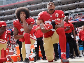 In this Oct. 2, 2016 file photo, San Francisco quarterback Colin Kaepernick, left, and safety Eric Reid kneel during the national anthem before an NFL football game against the Dallas Cowboys in Santa Clara, Calif.  (AP Photo/Marcio Jose Sanchez, File)