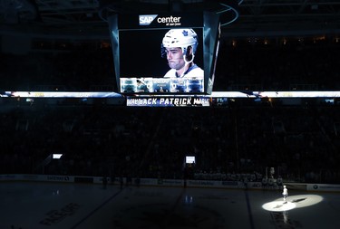 A spotlight flashes on Toronto Maple Leafs center Patrick Marleau, bottom right, as he is honored before an NHL hockey game against the San Jose Sharks, his former team, Monday, Oct. 30, 2017, in San Jose, Calif. (AP Photo/Marcio Jose Sanchez) ORG XMIT: SJA103