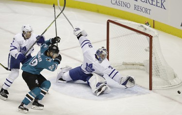 Toronto Maple Leafs goalie Frederik Andersen, right, deflects a shot in front of San Jose Sharks' Mikkel Boedker (89) during the first period of an NHL hockey game Monday, Oct. 30, 2017, in San Jose, Calif. (AP Photo/Marcio Jose Sanchez) ORG XMIT: SJA106