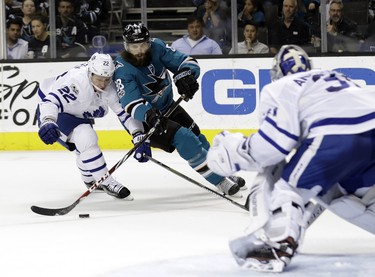 San Jose Sharks' Brent Burns, center, is defended by Toronto Maple Leafs' Nikita Zaitsev (22) during the second period of an NHL hockey game Monday, Oct. 30, 2017, in San Jose, Calif. (AP Photo/Marcio Jose Sanchez) ORG XMIT: SJA109