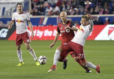New York Red Bulls midfielder Daniel Royer (77) controls the ball as Toronto FC midfielder Michael Bradley (4) defends during the first half of an MLS Eastern Conference semifinal soccer match Monday, Oct. 30, 2017, in Harrison, N.J. Looking on is Red Bulls midfielder Sacha Kljestan (16). (AP Photo/Bill Kostroun) ORG XMIT: NJBK105