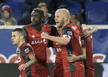 Toronto FC midfielder Michael Bradley (4) celebrates a goal by Victor Vazquez, rear right, during the first half of an MLS Eastern Conference semifinal soccer match against the New York Red Bulls Monday, Oct. 30, 2017, in Harrison, N.J. (AP Photo/Bill Kostroun) ORG XMIT: NJBK101