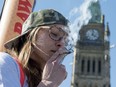 A woman smokes a joint during the annual 420 marijuana rally on Parliament hill on Wednesday, April 20, 2016 in Ottawa. THE CANADIAN PRESS/Justin Tang