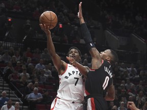 Toronto Raptors guard Kyle Lowry drives to the basket on Portland Trail Blazers guard Damian Lillard during the first quarter of an NBA basketball game in Portland, Ore., Monday, Oct. 30,  (AP Photo/Steve Dykes)