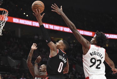 Portland Trail Blazers guard Damian Lillard drives to the basket on Toronto Raptors center Lucas Nogueira during the third quarter of an NBA basketball game in Portland, Ore., Monday, Oct. 30, 2017. The Raptors won 99-85. (AP Photo/Steve Dykes) ORG XMIT: ORSD115