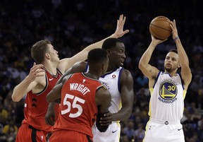 Golden State Warriors' Stephen Curry, right, shoots against Toronto Raptors' Jakob Poeltl, left, as Warriors' Draymond Green, second from right, blocks Raptors' Delon Wright (55) during the second half of an NBA basketball game Wednesday, Oct. 25, 2017, in Oakland, Calif. Warriors won, 117-112. (AP Photo/Ben Margot)