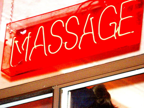 A neon sign in the window of an exotic massage parlour in the city.