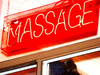 A neon sign in the window of an exotic massage parlour in the city.