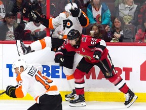 Ottawa Senators defenceman Erik Karlsson sends Philadelphia Flyers centre Travis Konecny flying on Oct. 26, 2017. (THE CANADIAN PRESS/Adrian Wyld)