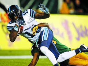 Toronto Argonauts' S. J. Green, front, makes a catch for a convert as Edmonton Eskimos' Brandyn Thompson tries to stop him during second half CFL football action in Edmonton, Saturday, Oct. 14, 2017. THE CANADIAN PRESS/Jeff McIntosh