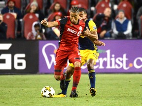 Toronto FC's Justin Morrow, left, takes possession of the ball in front of New York Red Bulls' Tyler Adams during first half MLS soccer action Saturday September 30, 2017 in Toronto. THE CANADIAN PRESS/Jon
