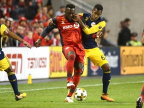 Toronto FC's Jozy Altidore, left, fights for the ball against New York Red Bulls' Michael Murillo during first half MLS soccer action Saturday September 30, 2017 in Toronto. THE CANADIAN PRESS/Jon Blacker