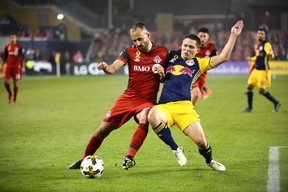 Toronto FC's Victor Vazquez, left, fights for the ball against New York Red Bulls' Connor Lade during second half MLS soccer action Saturday September 30, 2017 in Toronto. THE CANADIAN PRESS/Jon Blacker