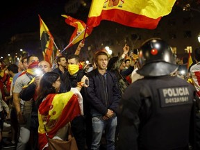 Catalan riot police stands as anti-independence supporters march against the unilateral declaration of independence approved earlier by the Catalan parliament in downtown Barcelona Friday, Oct. 27, 2017.