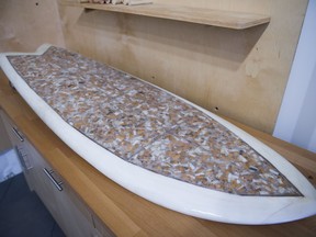 This Oct. 20, 2017, photo shows a surfboard that Taylor Lane, of Santa Cruz, Calif., made with 10,000 discarded cigarette butts for the annual "Creators & Innovators Upcycle Contest" at the Ecology Center in San Juan Capistrano, Calif. (Matt Masin/The Orange County Register via AP)