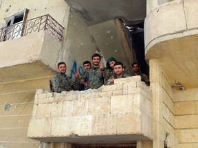 In this picture taken on Monday Oct. 16, 2017 and provided by The Syrian Democratic Forces (SDF), a U.S.-backed Syrian Kurdish forces outlet that is consistent with independent AP reporting, shows Syrian Democratic Forces (SDF) fighters, flash victory signs at the front line where they battle against the Islamic State militants, in Raqqa, Syria. (Syrian Democratic Forces, via AP)