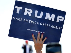 In this March 19, 2016, file photo, a supporter holds a sign as then Republican presidential candidate Donald Trump speaks during a campaign rally in Fountain Hills, Ariz.