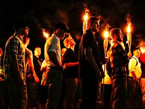 In this photo taken Friday, Aug. 11, 2017, multiple white nationalist groups march with torches through the UVA campus in Charlottesville, Va. Hundreds of people chanted, threw punches, hurled water bottles and unleashed chemical sprays on each other Saturday after violence erupted at a white nationalist rally in Virginia.