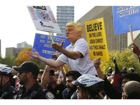 An anti-Trudeau protestor dress as Pres. Trump shouts over police line separating two opposite groups, right wing vs antifa at Toronto City Hall on Saturday October 21, 2017. Michael Peake/Toronto Sun/Postmedia Network
Michael Peake, Michael Peake/Toronto Sun