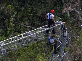 In this Oct. 15, 2017, file photo, Whitefish Energy Holdings workers restore power lines damaged by Hurricane Maria in Barceloneta, Puerto Rico.