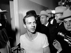 In this Nov. 23, 1963, file photo, surrounded by detectives, Lee Harvey Oswald talks to the media as he is led down a corridor of the Dallas police station for another round of questioning in connection with the assassination of U.S. President John F. Kennedy.