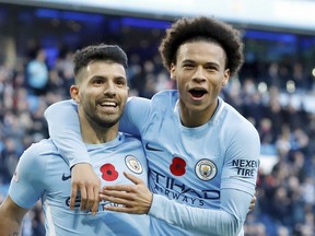 Manchester City's Sergio Aguero (left), celebrates scoring his side's second goal of the game with teammate Leroy Sane against Arsenal on Sunday. (AP)