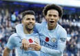 Manchester City's Sergio Aguero (left), celebrates scoring his side's second goal of the game with teammate Leroy Sane against Arsenal on Sunday. (AP)