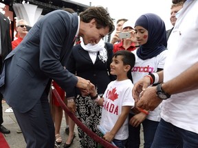 Prime Minister Justin Trudeau greets members of a Syrian refugee family during Canada Day celebrations on Parliament Hill, in Ottawa on Friday, July 1, 2016.
