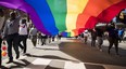 People carry a large rainbow flag at the Toronto Pride parade.