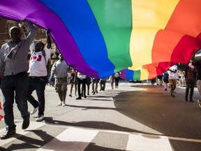 People carry a large rainbow flag at the Toronto Pride parade.