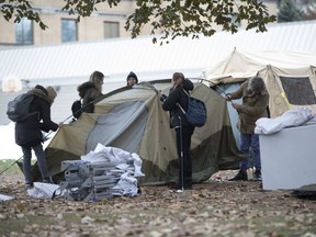 Volunteers assemble a tent at a harm-reduction site at Moss Park.